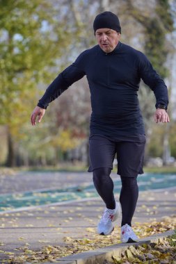 Bir sonbahar günü parkta koşan orta yaşlı bir adamın portresi..