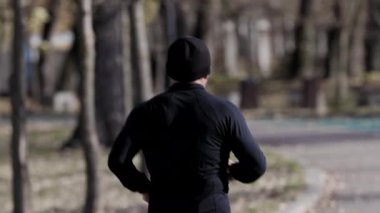 Bir sonbahar günü parkta koşan orta yaşlı bir adam..