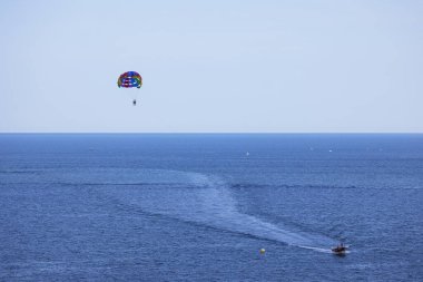 Tatil köyünde deniz kenarında paraşütle atlayan turistlerin görüntüsü. Turizm kavramı.