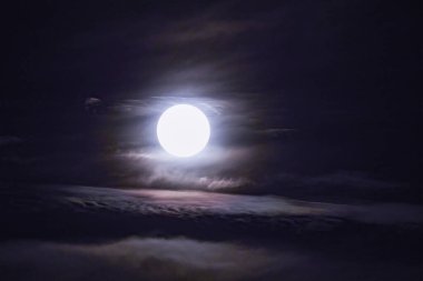 Gün batımından bir saat sonra bulutlu bir akşamda dolunay..