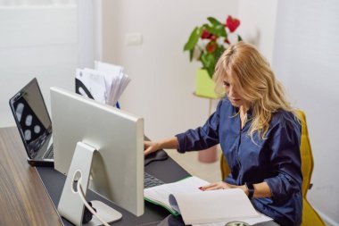 İşe dönmek, ofiste çalışan orta yaşlı bir iş kadını, farklı pozlar..
