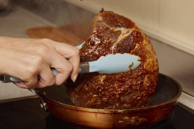 Elektrikli ocağın tepsisindeki domuz boynu parçası..