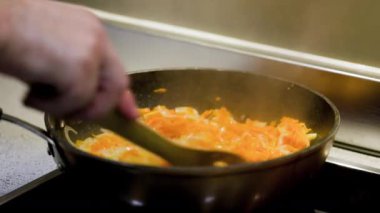 Soğanlı bir tava, fırında biber ve havuç pişiyor.