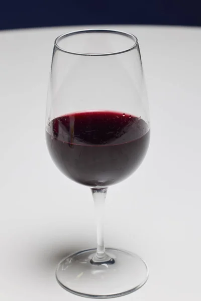 a glass of red wine on a table