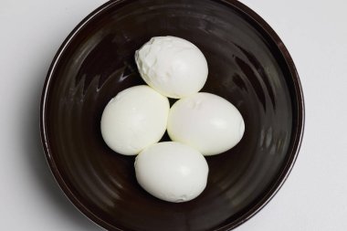Bir kasede haşlanmış ve soyulmuş yumurta..