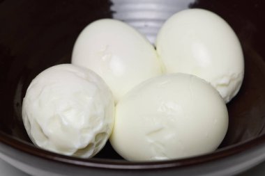 Bir kasede haşlanmış ve soyulmuş yumurta..
