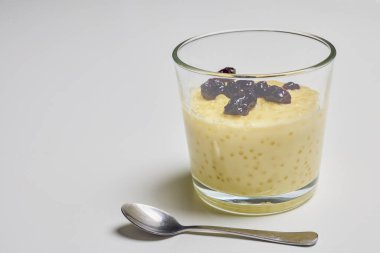 Tatlı ile bir cam kase, vanilyalı muhallebi ve yaban mersini reçeli.