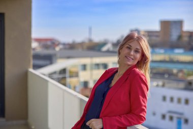 Güneşli bir günde balkonda sigara içen bir kadın..