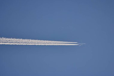 Mavi gökyüzünde iz bırakan bir kargo uçağı..