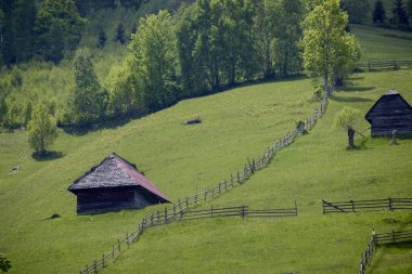 Romanya 'nın Bucegi dağlarında eski ahşap evleri olan dağ manzarası.