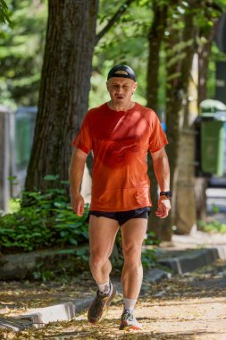 Ormanda koşan orta yaşlı güçlü bir adam.