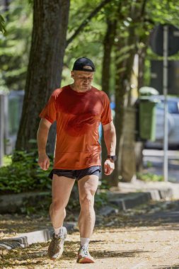 Ormanda koşan orta yaşlı güçlü bir adam.