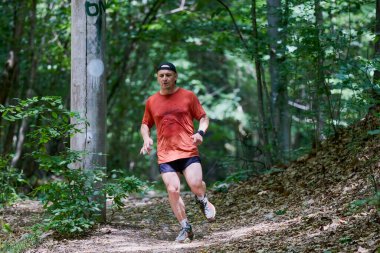 Ormanda koşan orta yaşlı güçlü bir adam.