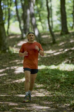 Ormanda koşan orta yaşlı güçlü bir adam.