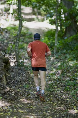 Ormanda koşan orta yaşlı güçlü bir adam.
