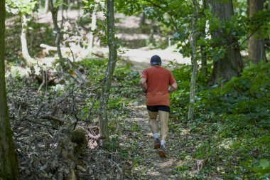 Ormanda koşan orta yaşlı güçlü bir adam.