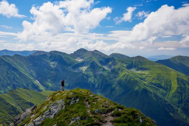Orta yaşlı bir adam dağda yürüyor.
