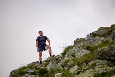 Orta yaşlı bir adam dağda yürüyor.