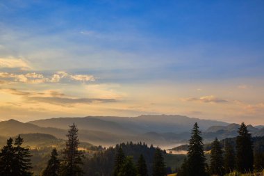 Romanya 'nın Karpat Dağları' ndan Piatra Craiului dağlarıyla gün batımında manzara.