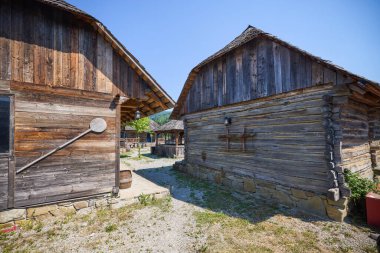 Maramures, Romanya 'dan farklı geleneksel evlere sahip peyzaj, ağırlıklı olarak ahşaptan yapılmış evler.