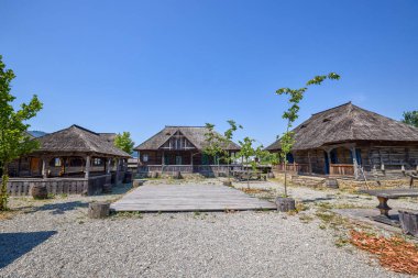 Maramures, Romanya 'dan farklı geleneksel evlere sahip peyzaj, ağırlıklı olarak ahşaptan yapılmış evler.