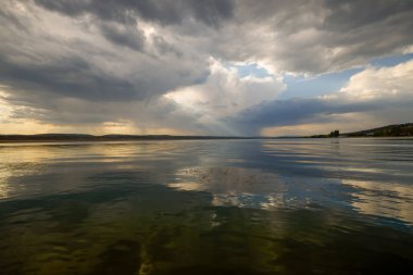 Göl üzerinde yağmur bulutları olan bir manzara..