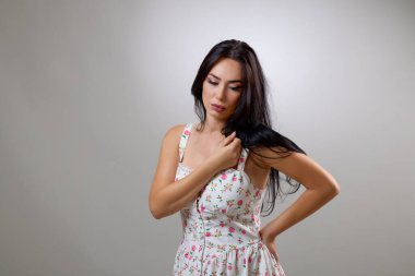 Stüdyoda yazlık bir elbise içinde güzel bir esmerin portresi..