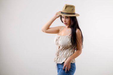 Gri arka planda farklı pozisyonlarda şapkalı güzel esmer bir kadının portresi.