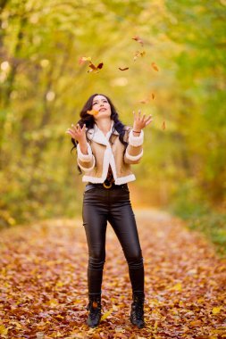 Güz ormanlarında bir yolda ceketi ve pantolonu dolu güzel bir kadının portresi..