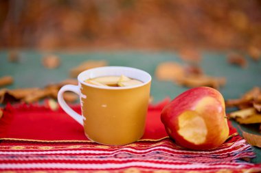 Bir bardak sıcak şarap ve masada bir elma.