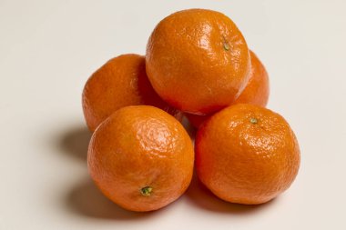 clementines placed on a white table clipart