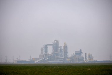 industrial landscape with a factory seen through the fog clipart