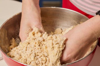 Pasta hamuruyla çalışan kadınların elleri.