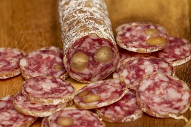 Tahta bir tahtanın üzerinde cevizli fuet salamı dilimleri