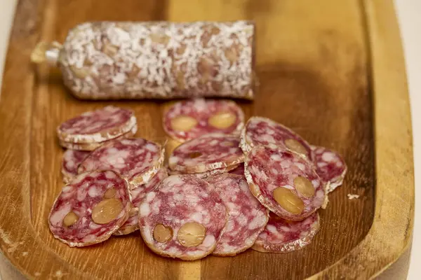 Tahta bir tahtanın üzerinde cevizli fuet salamı dilimleri