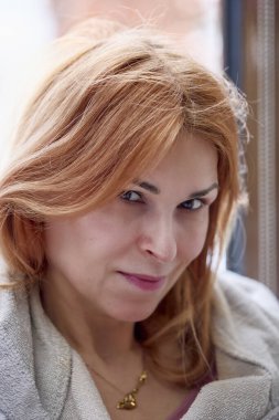 Sıradan kıyafetler giymiş orta yaşlı bir kadının portresi.