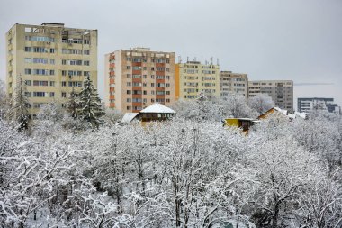 Kış günü üzerinde kar olan bir şehrin binalarının manzarası