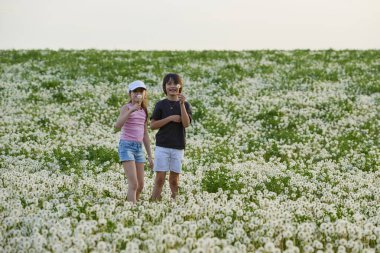 Karahindiba otlağında oynayan iki sevimli çocuk..