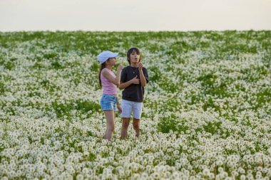 Karahindiba otlağında oynayan iki sevimli çocuk..