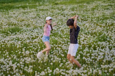Karahindiba otlağında oynayan iki sevimli çocuk..