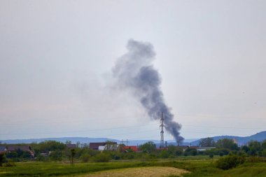 Yerden yükselen siyah dumanlı kırsal alan