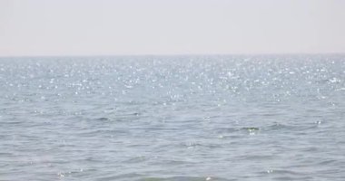 4k, güçlü yaz güneşinde parlayan bir denizin yüzeyiyle