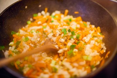 Tavanın yanına doğranmış sebzeler ve tahta bir kaşık koyun.