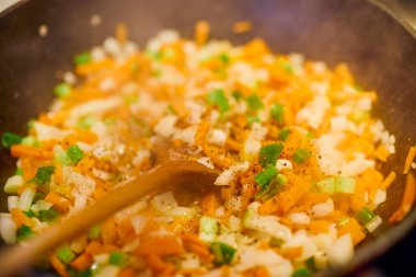 Tavanın yanına doğranmış sebzeler ve tahta bir kaşık koyun.