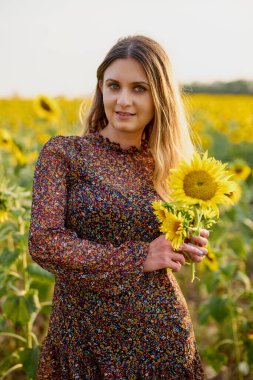 Bir yaz günü çiçek açan bir tarlada güzel bir kadın.