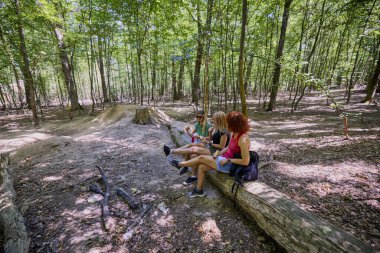 Bir grup orta yaşlı bayan arkadaş ormanda yürüyüş yapıyor ve dinleniyorlar..