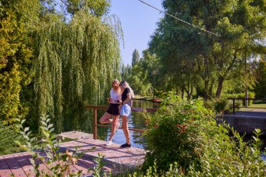 İki orta yaşlı kız kardeş bir yaz sabahını parkta dinlenerek ve eğlenerek geçiriyorlar..