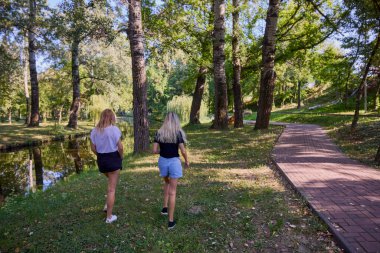 İki orta yaşlı kız kardeş bir yaz sabahını parkta dinlenerek ve eğlenerek geçiriyorlar..