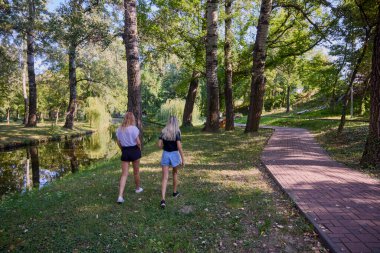 İki orta yaşlı kız kardeş bir yaz sabahını parkta dinlenerek ve eğlenerek geçiriyorlar..