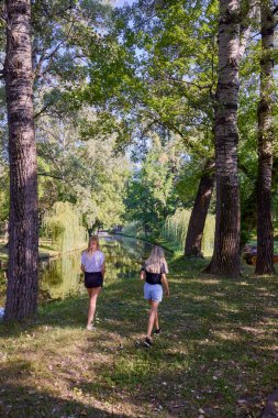 İki orta yaşlı kız kardeş bir yaz sabahını parkta dinlenerek ve eğlenerek geçiriyorlar..